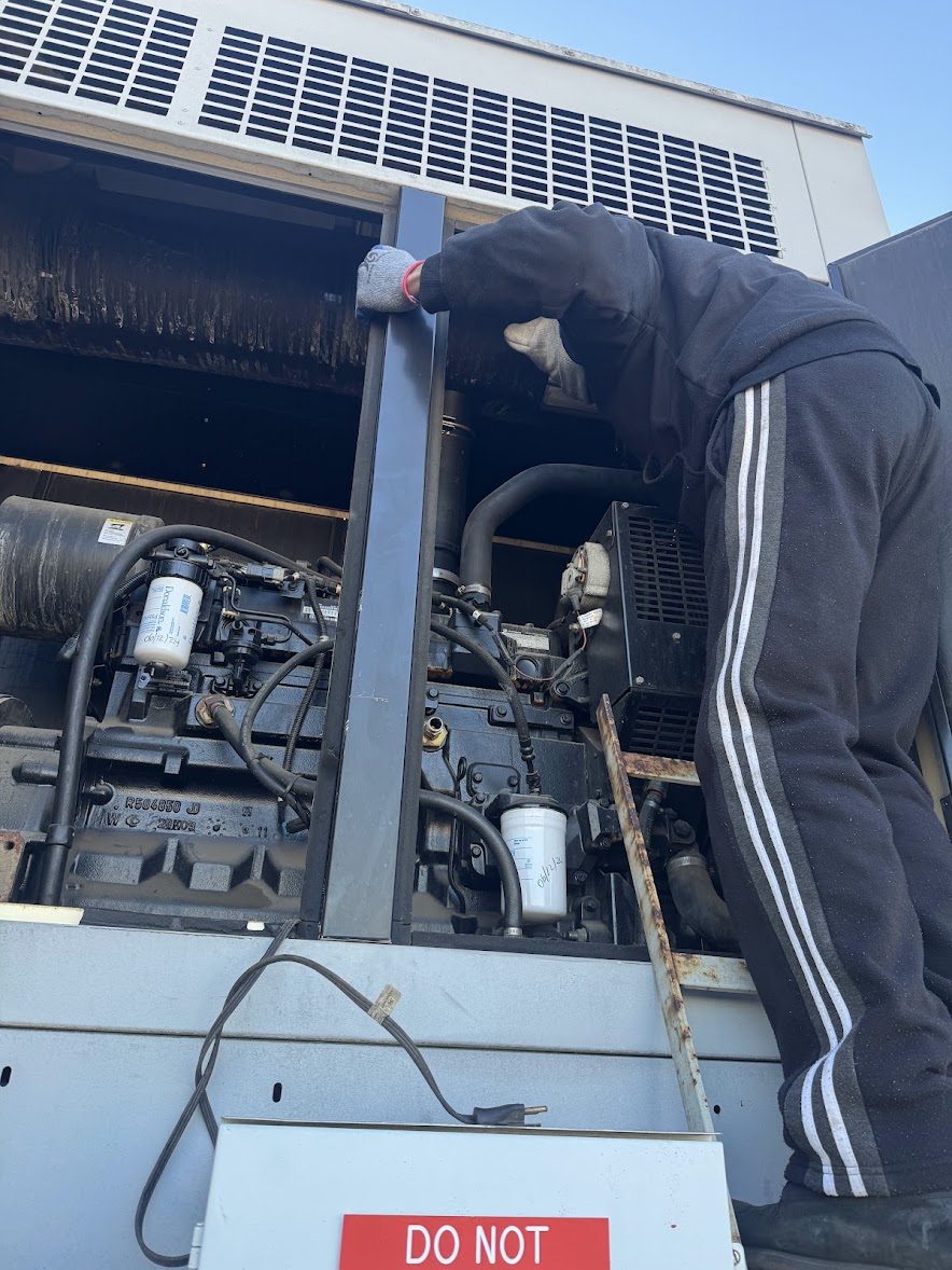 A2Z technician performing generator repair on a standby diesel engine